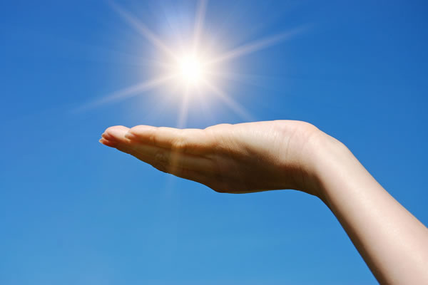 female hand appears to hold up the sun